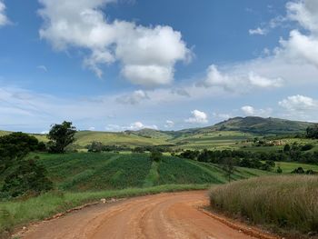 Road amidst field against sky