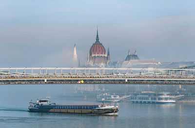 Boats on danube river on a misty morning in budapest, hungary