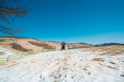 Scenic view of landscape against clear blue sky during winter