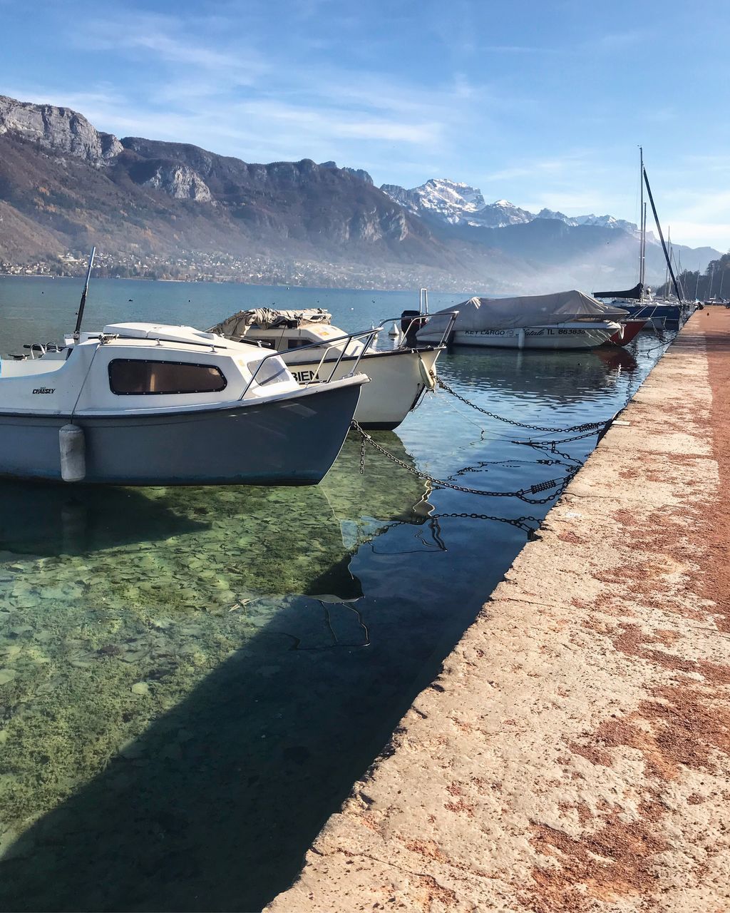 BOATS MOORED ON SEA AGAINST MOUNTAIN