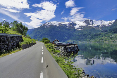 Road amidst snowcapped mountains against sky