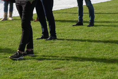 Low section of people standing on grass