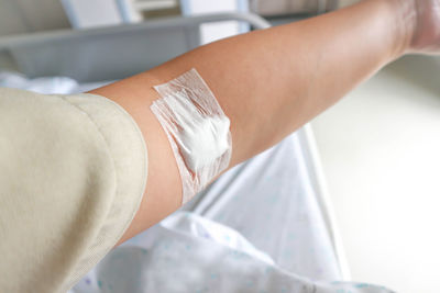 Cropped image of woman with bandage on hand in hospital