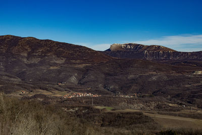 Scenic view of landscape and mountains against clear blue sky