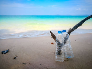 Water bottle on beach against sky