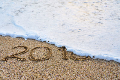 High angle view of text on beach