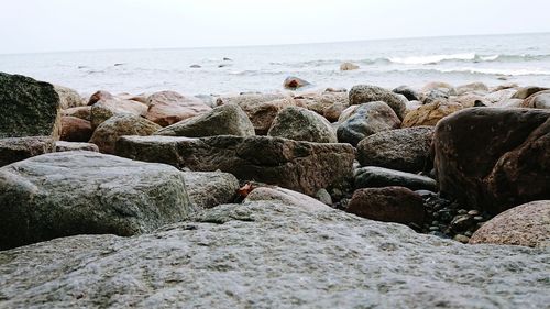 Rocks on beach against clear sky