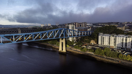 Bridge over river against cloudy sky
