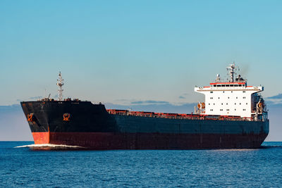 Ship sailing in sea against sky