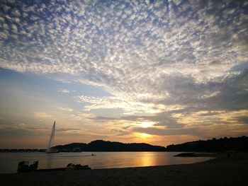 Scenic view of sea against dramatic sky during sunset