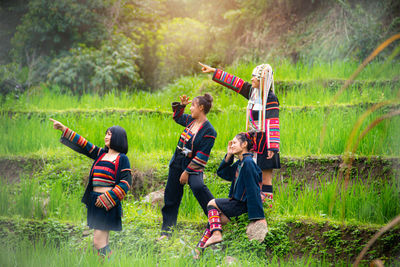 Rear view of people enjoying in grass