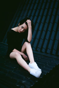 Beautiful young woman sitting on roof