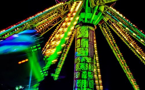 Low angle view of illuminated ferris wheel against sky at night