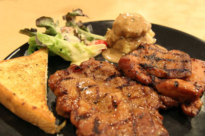 Grilled chicken and pork chop with salad, bread and mashed potato