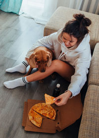 High angle view of woman and dog sitting at home