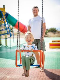 Happy boy swinging in playground