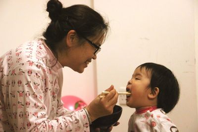 Mother feeding son with asian food