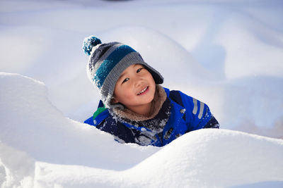 Portrait of smiling children standing on snow covered landscape