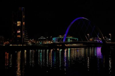 Reflection of illuminated bridge in water at night