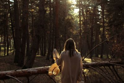 Rear view of woman walking in forest