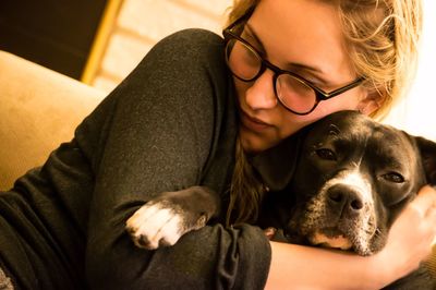 Close-up of woman hugging dog at home