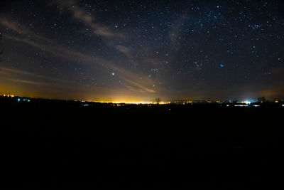 Silhouette landscape against star field at night