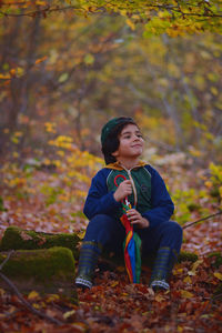 Portrait of young woman sitting on rock