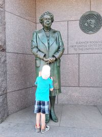 Full length portrait of man standing against wall