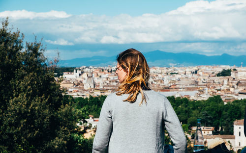 Rear view of man looking at cityscape