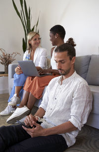 Friends sitting on sofa at home