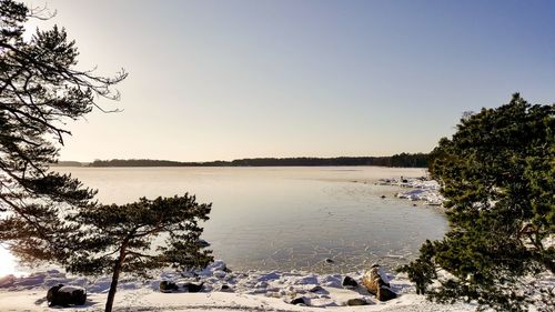 Scenic view of lake against clear sky during winter
