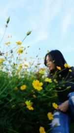 Close-up of woman with flowers against sky