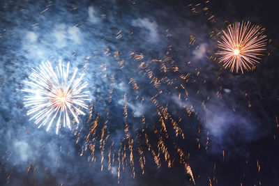 Low angle view of fireworks in sky at night