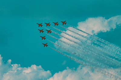 Low angle view of airplane flying against blue sky