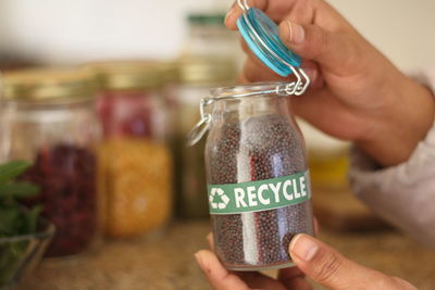 Midsection of woman holding ice cream in jar