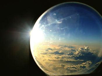 Scenic view of bright sun in sky seen through glass