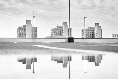 Reflection of buildings in city against sky