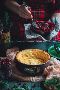 Traditional homemade french cake with cranberries served on green wooden table.