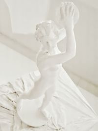 Close-up of angel statue against white wall