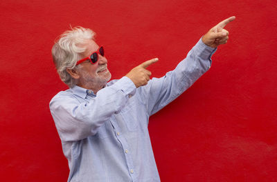 Full length of man standing against red wall