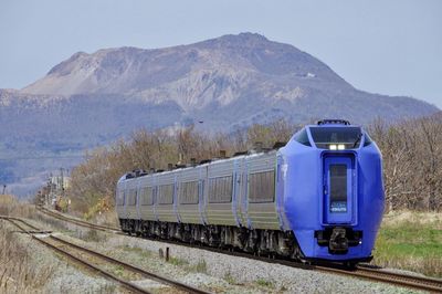 Train by railroad track against sky