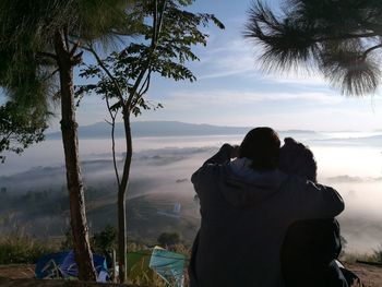 Rear view of couple sitting on beach