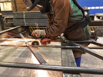 Man grinding metal in factory