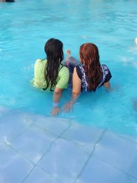 Rear view of friends in swimming pool