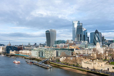 River amidst buildings in city against sky