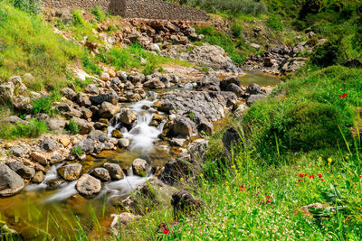 View of stream flowing through rocks