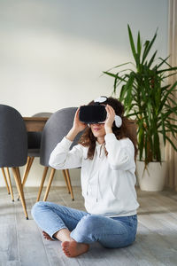 Young woman using mobile phone while sitting on sofa