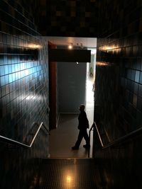 Man walking on staircase in illuminated building