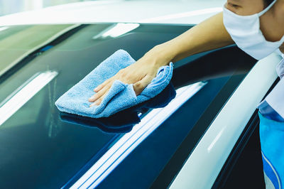 Midsection of man cleaning car