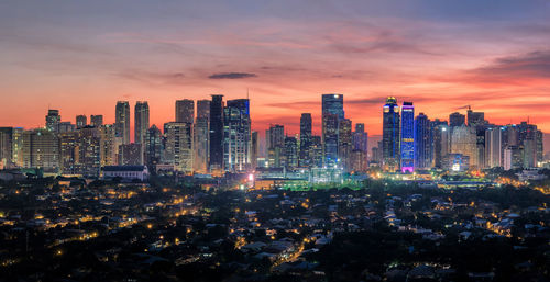 Illuminated buildings against sky during sunset